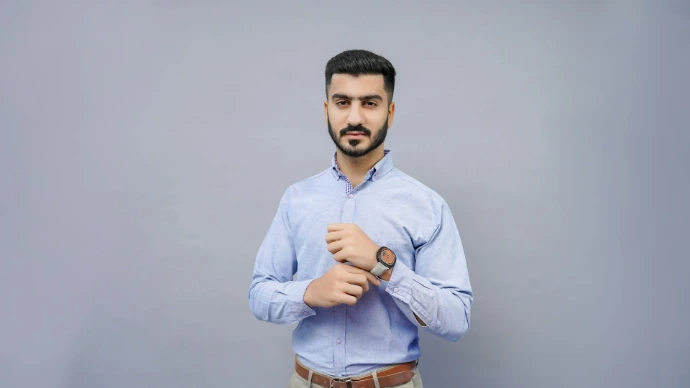 a man wearing a blue shirt and tan pants
